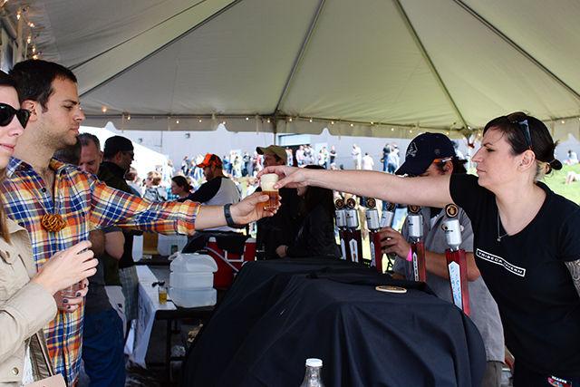 Servers at the Mash House Brewing tent pour beer samples for visitors at the World Beer Festival held at the NC State Fairgrounds on April 2, 2016. Mash House, based in Fayetteville, NC, is one of over 40 North Carolina breweries featured in the NC Beer Garden at the event.