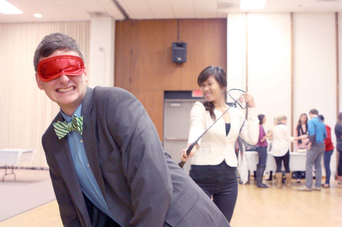 Philip Misklow, a then-senior studying communication, and Thy Bui, a then-junior studying communication, display ways to spice up sex life during the Sexual Communications Fair in Talley Student Center on the evening of Thursday, Nov. 30, 2012.