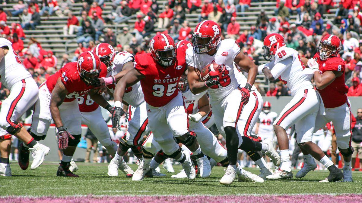 Junior runningback Jacob Davis runs out of the backfield pinned near the endzone as red team's junior defensive tackle Kentavius Street makes his pursuit. Davis had seven carries on the day for a net loss of five yards. The red team won the Kay Yow Spring Football Game 47-0 on April 9th in Carter Finley Stadium.