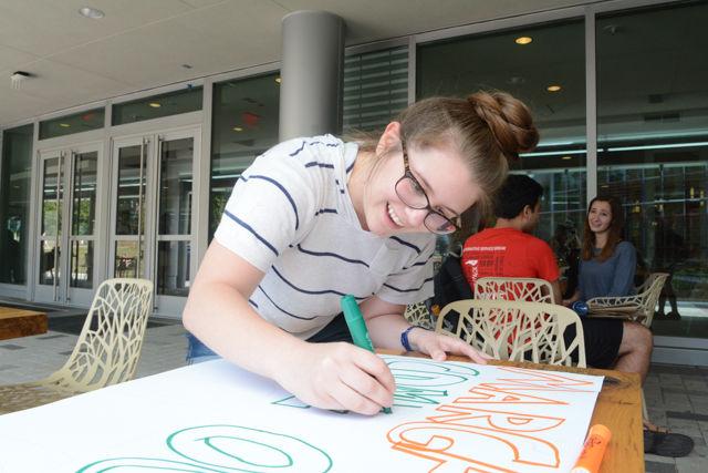 Hannah Fennell, a junior majoring in applied math, helps decorate a sign reading "Spellings, come out (of office)" to protest Margaret Spellings's visit to NC State's campus on Wednesday, April 20th. Protesters gathered on Stafford Commons and then in the lobby of Talley Student Union to show their opposition to Spellings taking the position of president of the UNC public university system.