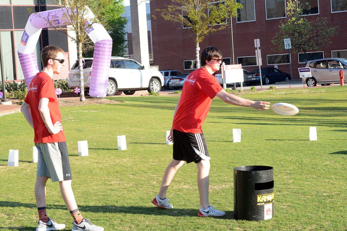Mason Kilbourne, a junior studying criminology, cheers on Corey Wilson, a junior studying animal science, during a game of Kan Jam by at the Relay for Life Party held on Harris Field Saturday. "We started setting up at around 9 a.m., teams came and started setting up at about 10:30 a.m. and the band has been playing and people have been walking since noon," said Samantha Gagnon, a sophomore studying biology who was also present at the party. The event, which lasted until about midnight, included walking laps to raise money for Relay for Life, various lawn games, baked goods sales and more.