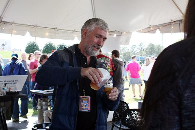 Dr. John Sheppard, Professor and Undergraduate Coordinator of Bioprocessing Science Program at NC State, serves samples of beer brewed using the program's research brewing supplies during the World Beer Festival held at the NC State Fairgrounds on April 2, 2016. Sheppard and his program serve brewing samples to over 50 NC State campus events per year and recently received their license to sell alcohol.