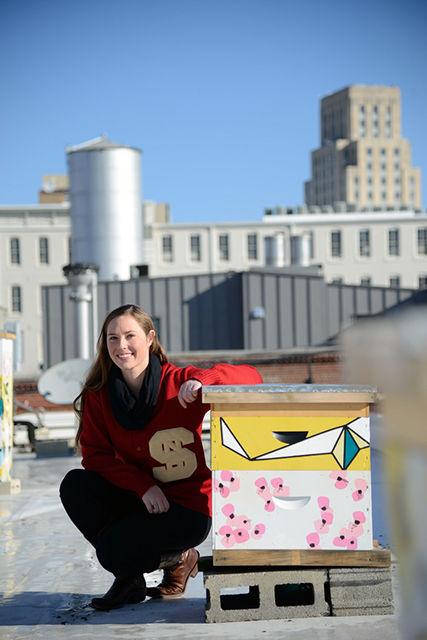 Leigh-Kathryn Bonner, the founder of Bee Downtown, sits next to a hive. Once a sponsor is found for the hive, Bee Downtown maintains the hive to bring bees to the environment of downtown Durham.