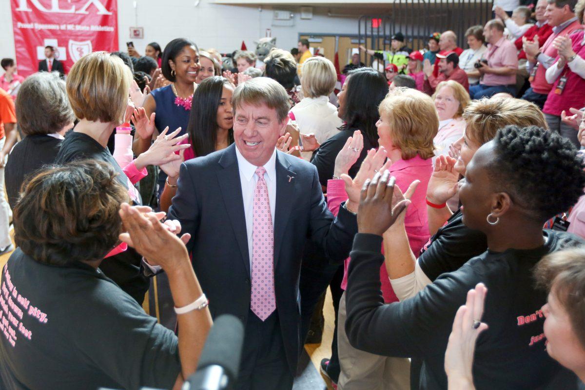 Head Coach Wes Moore enters through the alumni tunnel at the Hoops 4 Hope game on February 14th in Holliday Gymnasium at Broughton High School. The Wolfpack put up a tough fight against No. 22 Syracuse, but were unable to come out victorious ending 55-52.