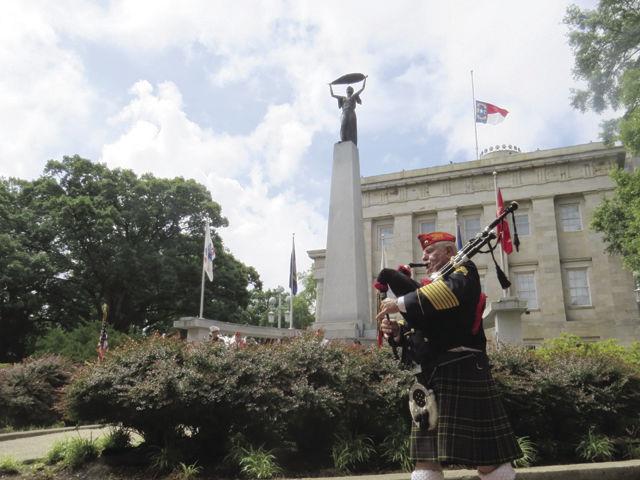 Robert White plays "Scotland the Brave" on the bagpipes while marching through a line of veterans saluting at the Memorial Day Ceremony at the Capitol on Monday.