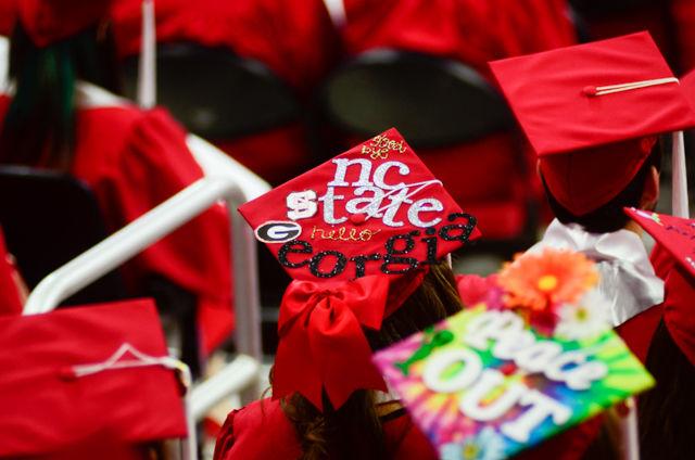 A "NC State rules Georgia" decorated cap sits on a graduate&#8217;s head on May 7, 2016 in PNC Arena during the 2016 Commencement Ceremony.