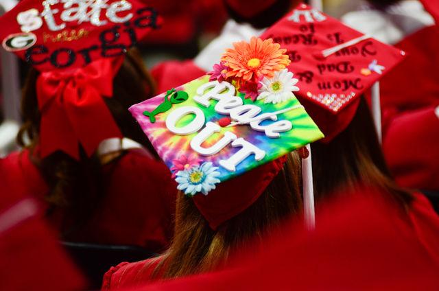 A groovy decorated cap sits on a graduate&#8217;s head on May 7, 2016 in PNC Arena during the 2016 Commencement Ceremony.