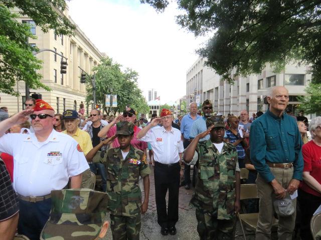 A group of veterans with the Marine Corps League Tarheel Detachment salute while a bagpiper plays "Scotland the Brave" during the Memorial Day ceremony at the Capitol on Monday.