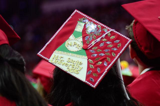 A "NPR Champagne" decorated cap sits on a graduate&#8217;s head on May 7, 2016 in PNC Arena during the 2016 Commencement Ceremony.
