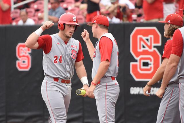Senior designated hitter Chance Shepard gets fist bumps from teammates as he heads back to the dugout after crossing the plate for a run in the Wolfpack's fourth game of the NCAA Raleigh Regional against Coastal Carolina on June 6, 2016. Shepard scored 2 runs in two at bats to help the Wolfpack rout the Chanticleers 8-1 at Doak Field to force a winner take all game.