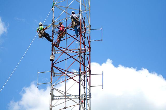 Dimensional Tower Inc tower climbers work up in the antenna tower on top of DH Hill Library to finish replacing parts of the antenna and tower setup on June 16, 2016. NC State's radio station, WKNC, uses the antenna to broadcast across the city. Over the past week, the antenna and transmitter have been repaired and modernized to allow the radio station to reach further and work smoother with the digital broadcast system that is now being used.
