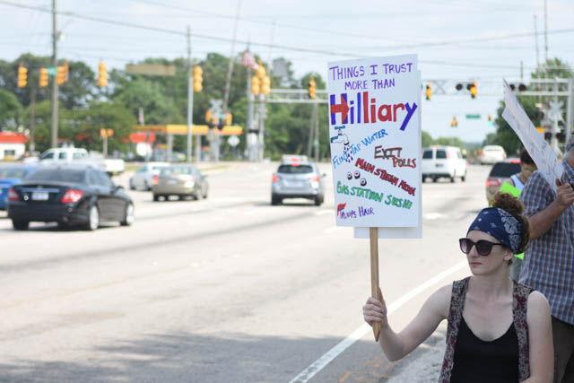Alrielle Bryant, Raleigh resident, protests Hillary Clinton at the end of her rally held on the corner of Hillsborough Street and Blue Ridge Road on Wednesday June 22.
