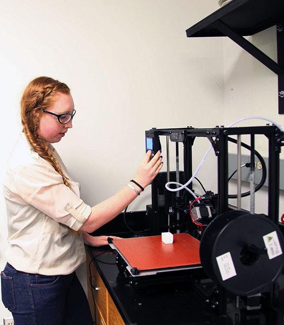 Alexa Kearns, a graduate student studying textile engineering, works on a 3-D printer. New 3-D-printing materials are being explored for sustainable packaging of electronics by the addition of cotton materials to the synthetic polymers typically used in 3-D printing.