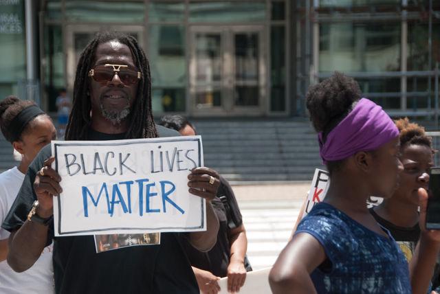 Thomas Vinson, a member of the Charlotte local organizing committee for Black Lives Matter, protests along with 30 others in front of the Administration building. Many of the protesters made the drive up from the Charlotte area to deliver the petition opposing HB 972 to Gov. Pat McCrory.