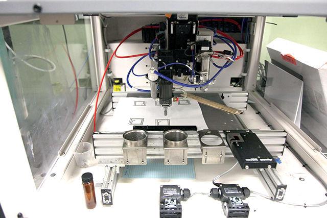 High-throughput processes are explored for printing electronics onto textiles. This instrument dispensed conductive inks onto textiles and films.