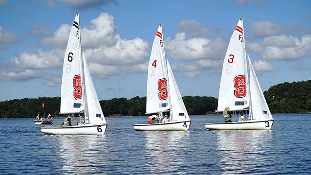 An NC State sail boat is flanked by two University of South Florida boats during the sailing club's first women&#8217;s regatta Sept. 19.