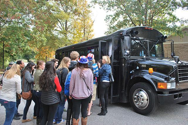 Students board the Cosmopolitan party bus back to campus after casting their votes at Freedom Temple Church on Nov. 4, 2014. The buses were filled with lights and loud music to provide entertainment for students while on their way to the polls.