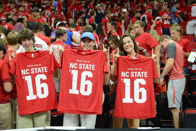 Hanson Lucas, a freshman studying English, Pierce Strayer, a freshman in exploratory studies, and Rachel Magoon, also a freshman in exploratory studies, throw the wolfie as they hold their class shirt at Convocation on Aug. 15, 2016 at PNC Arena.