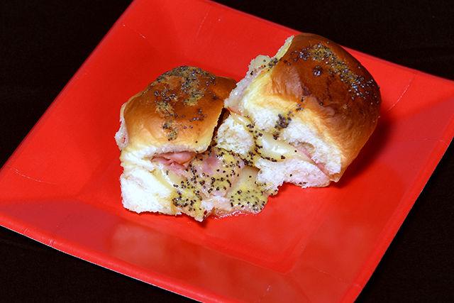 Ham and cheese sliders are made with Hawaiian rolls and are topped with a poppy seed mustard dressing.&#160;