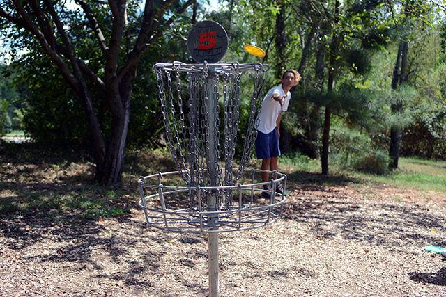 Dylan Reinhardt, a graduate student studying biological and agricultural engineering, throws a Frisbee into a basket during a round of disc golf at the course on Centennial Campus Thursday. Reinhardt is the president of the NC State student chapter of NORML, the National Organization for Reform of Marijuana Laws. The organization started on campus in fall 2015 and, according to member and junior studying art and design, Matt Gluf, its purpose is to "open the conversation up" about and raise awareness of the issue of marijuana law reform. The organization has sponsored events in the past such as picking up trash on the Greenway.