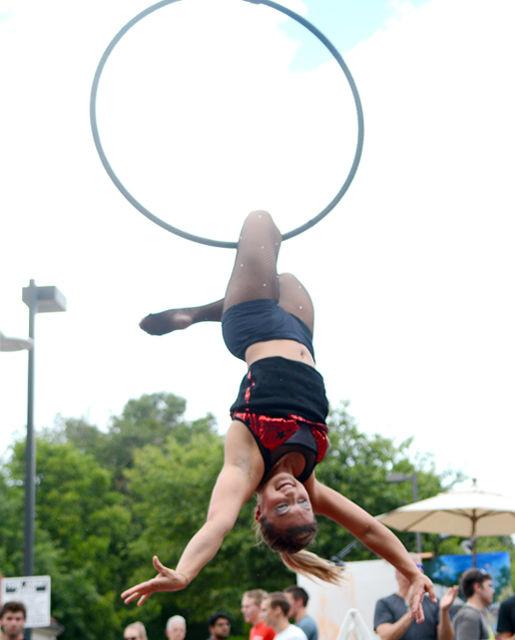 The crowd watches as Nina Spiering from Cirque du Vol performs upside down in a hoop during an aerialist routineon Hillsborough Street duriing Packapalooza on Aug. 20. Cirque du Vol was among the many performers during NC State's annual event.