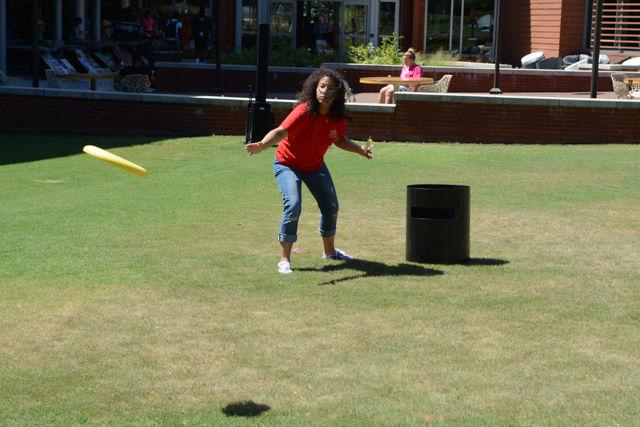 Idalys Hernandez, a senior studying animal science, throws a frisbee while holding a pineapple orange blossom popsicle during a game of KanJam at the Pack the Lawn Party on the Stafford Lawn Aug. 18. The purpose of Pack the Lawn Party was to promote University Recreation and Outdoor Adventures as well as to promote a healthy lifestyle by having students' pictures taken with the hashtag Pack in Action. Students were able to play games such as KanJam and cornhole and also get free popsicles. When asked what brought her out to the event, Hernandez said, "I just wanted to have some fun with my roommate."