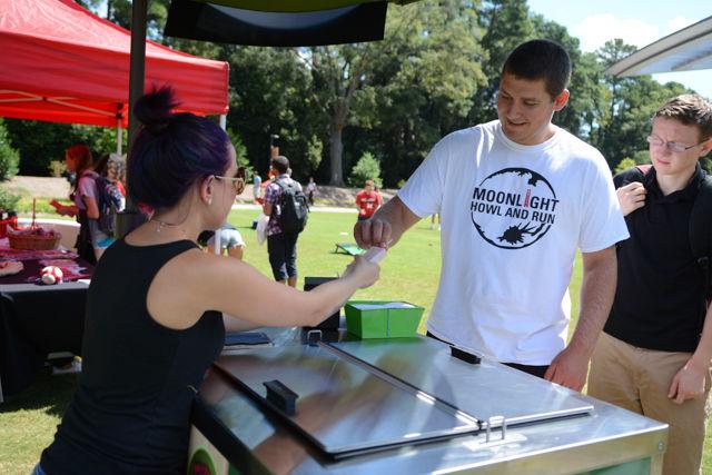 Hunter Rollins, a freshman studying mechanical engineering, receives a free popsicle from April Setola-Cyr, a local vendor during the Pack the Lawn Party held on Stafford Lawn beside Talley Aug. 18. The purpose of Pack the Lawn Party was to promote University Recreation and Outdoor Adventures as well as to promote a healthy lifestyle by having students' pictures taken with the hashtag Pack in Action. Students were able to play games such as KanJam and cornhole and also get free popsicles.