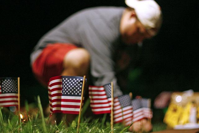 The Committee for a Better University and the College Republicans work together to create a memorial to remember 9/11. Patrick Lawson, a graduate student studying psychology, places flags in the ground to represent the American lives lost. &#8220;It was very organic the way it all came together; everyone here is a volunteer and were enthused about being here at 10 at night,&#8221; Lawson said. A group of students stayed overnight to guard the memorial; they will be out all day handing out ribbons and allowing students to stop by and write letters for the troops.