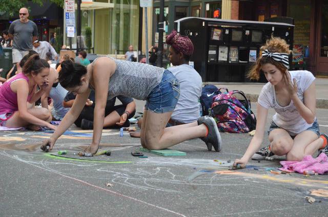 Apex High School seniors Leila deMarchi and Ednora de Hostos Lopez draw on Fayetteville street during SPARKcon XI on Sept. 16. The seniors created drawings of characters from Overwatch, a popular video game. SPARKcon ended on Sept. 18.