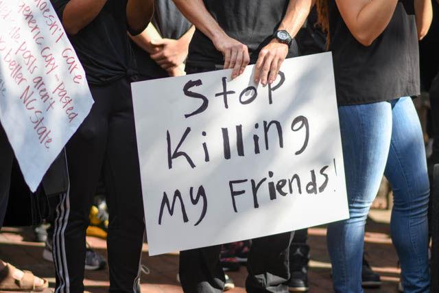 A student attending the Blackout event holds a sign that reads "Stop Killing my Friends!" Students gathered in Wolf Plaza on Sept. 23 to listen to speakers and bring awareness to the recent events that took place in both Charlotte and Tulsa.