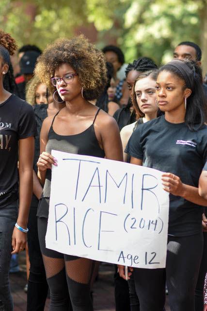 Two students attending the Blackout event hold a sign that reads "Tamir Rice (2014)," who was a victim to police brutality. Students gathered in Wolf Plaza on Sept. 23 &#160;to listen to speakers and bring awareness to the recent events that took place in both Charlotte and Tulsa.