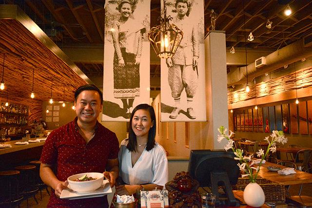 Vansana Nolintha, co-founder of the Laotian restaurant Bida Manda in downtown Raleigh, holds a bowl of pork belly soup while standing next to his sister and co-founder Vanvisa in front of photographs of their parents, their restaurant's honorees, at the front lobby Monday. Bida Manda was founded in 2012, three years after Vansana graduated from NC State with a degree in design and one year after Vanvisa graduated from UNC Greensboro with a degree in hospitality and hotel restaurant management.&#160;