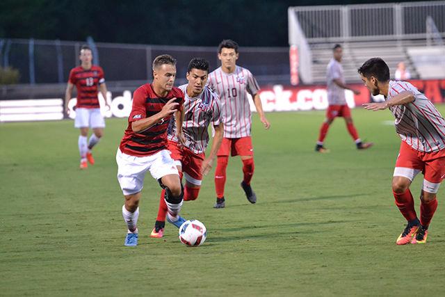 Freshman forward Stephen Elias weaves past Liberty midfielder Alan Arellano &#160;in Dail Soccer Stadium Tuesday. The NC State Wolfpack defeated the Liberty Flames by a score of 3-1.