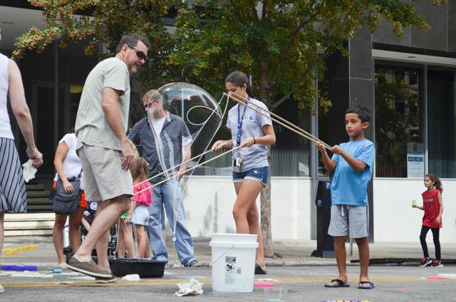 Charlie Berko makes huge bubbles by criss-crossing two poles at SPARKcon on Sept. 18. As the poles were moved apart, wind pushed through the bubble mixture and produced a bubble nearly 10 times the average bubble size. The huge bubbles were a hit among both kids and adults.