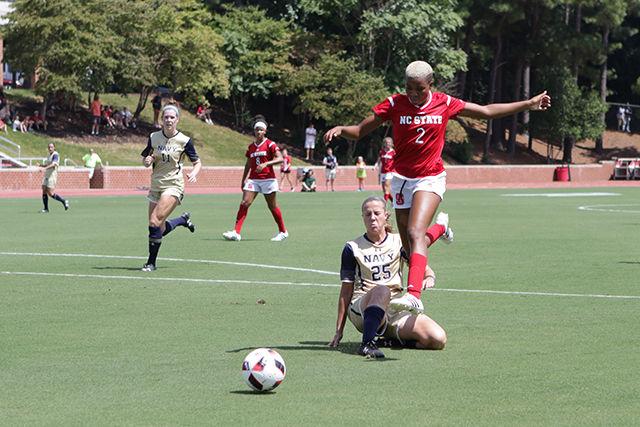 Freshman midfielder Tziarra King leaps over Navy's Meghan Hegarty on her way toward the goal. King showed her prowess with five shots, three on goal with two scores in her 62 minutes of play. The Wolfpack dominated the Naval Academy for a 4-1 home opener in Dail Soccer Stadium Aug. 28.