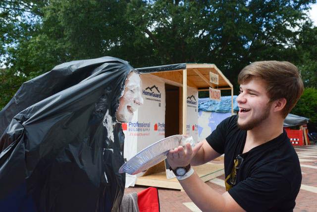 Carl Staub, a freshman studying engineering, pies Alex Obiol, also a freshman studying engineering, in the face as part of the Pie-a-Park fundraiser at the Park Shack on the last day of Shack-a-Thon Friday. "It was just good fun for a good cause," Staub said.&#160; Volunteers with the shack took $3 donations for people to pie them in the face. The annual fundraiser to raise money for Habitat for Humanity included 26 shacks built by representatives of various student organizations on campus.