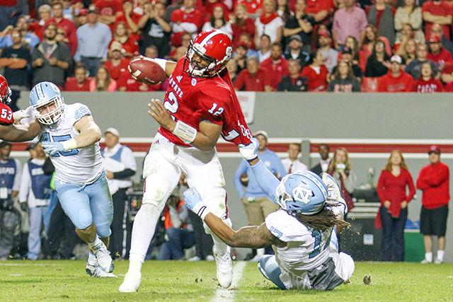 Redshirt senior quarterback Jacoby Brissett gets pulled from behind by a UNC-Chapel Hill defender while attempting to escape the pocket. Brissett finished 17-for-37 &#160;with 206 passing yards and two touchdowns and one interception. The NC State Wolfpack fell to the UNC Tar Heels in the last home game of the season, 45-34, at Carter-Finley Stadium Nov. 28.
