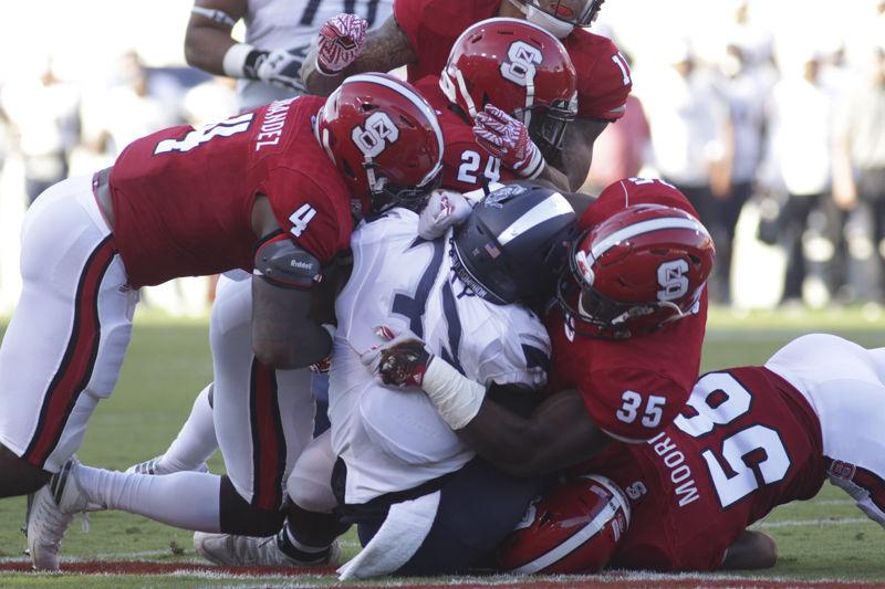 Redshirt junior linebacker Jerod Fernandez, junior safety Shawn Boone and junior defensive end Kentavius Street tackle an Old Dominion University runner during their game on Sept. 17, 2016. The Wolfpack defense held the Monarch offensive to just 117 rushing yards in NC State's 49-22 win at Carter-Finley Stadium.
