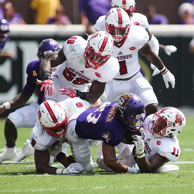 A host of NC State defenders take down ECU's Quay Johnson during the Wolfpack loss to ECU 33-30 Saturday in Dowdy-Ficklen Stadium.