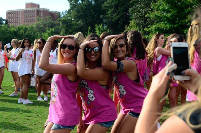 Rachel Eller, a freshman studying studying life sciences, Kasey Noll, a freshman studying life sciences, and Jenna Bryan a freshman studying statistics, throw the Delta Gamma sign while posing for a picture during Bid Day at Stafford Commmons on September 14.