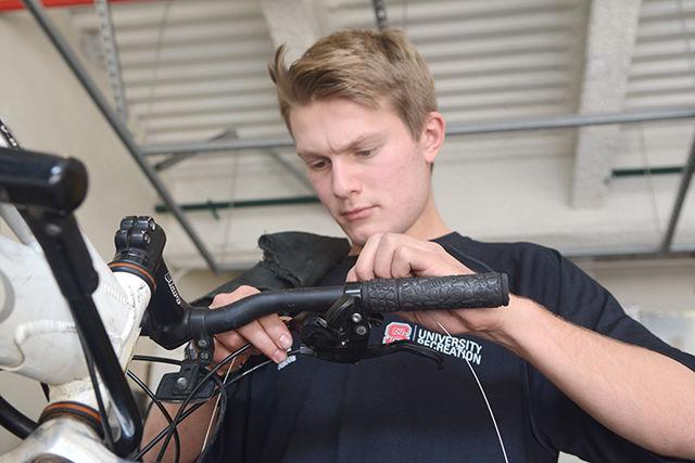 Johnny Davis, a sophomore studying electrical engineering, repairs another student's bike at University Recreation's Equipment Rental Center on Friday. The bike repair program repairs students' bikes for free on Fridays from 3-6 p.m. Students are required to bring parts if their bike needs it.