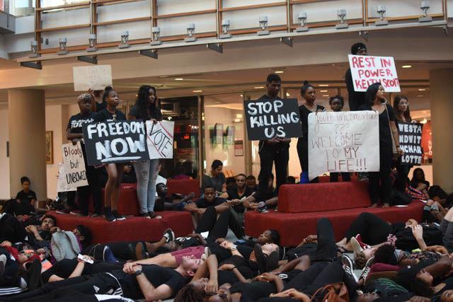A students attending the NC State Blackout hold signs during the die-in portion of the event. Participants covered the floor of the atrium in Talley Student Union on Sept. 23 in silence to represent all the lives lost to police brutality.