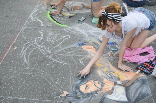 Ednora de Hostos Lopez, a senior at Apex High School, draws a chalk picture of Overwatch characters at SPARKcon on Sept. 16. SPARKcon is an arts festival on Fayetteville street in downtown Raleigh. SPARKcon started in 2006.
