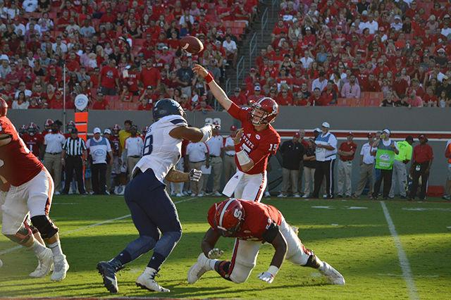 Quarterback Ryan Finley throws the ball to a teammate before being tackled by Old Dominion's defensive end Oshane Ximines. Finley was sacked once during the game, and passed a total of 281 yards. The Wolfpack beat the Monarchs, 49-22, in Carter-Finley Stadium on Sept. 17.&#160;