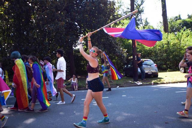 Emily York, a senior at North Carolina School of Science and Mathematics, marches in the Pride Parade held on East Campus at Duke University on Saturday. York waves a blue, purple and pink flag, which represents bisexuality.