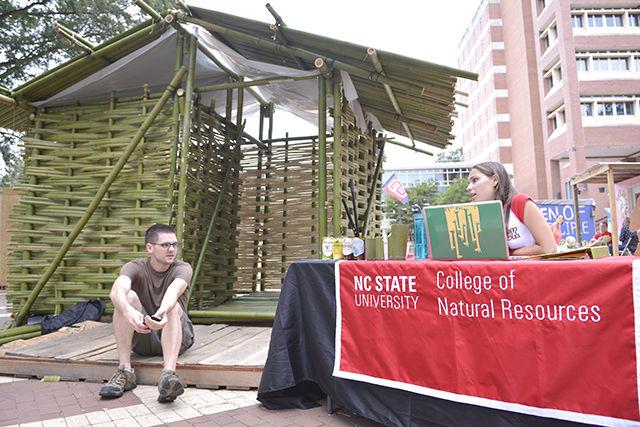 Darren Stebbins, a senior studying forest management, discusses ways to help raise money for Habitat for Humanity with Miranda Day, a junior studying parks, recreation and tourism management and head of fundraising for the College of Natural Resources shack during the Shack-A-Thon fundraiser in the Brickyard on Sept. 21, 2015. Their shack is made out of bamboo and, according to build coordinator for the shack and senior studying forest management Dillon Dunn, it took hundreds of hours to build and involved the use of a machete.&#160;