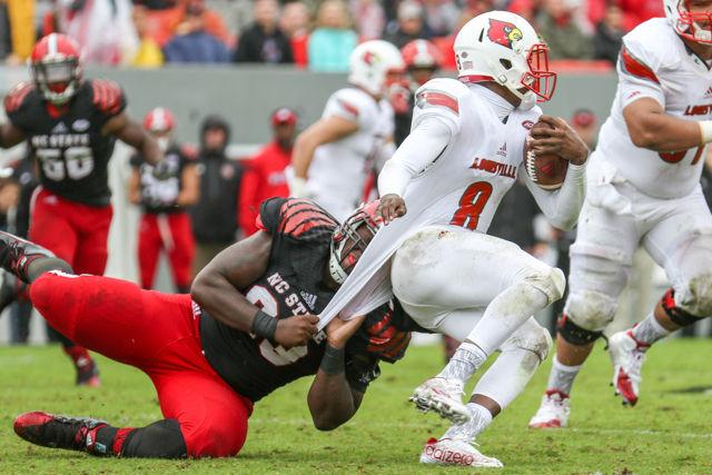 The Louisville quarterback is pulled down but escapes another tackle in the 20-13 loss to Louisville in Carter-Finley Stadium on Oct. 3, 2015.