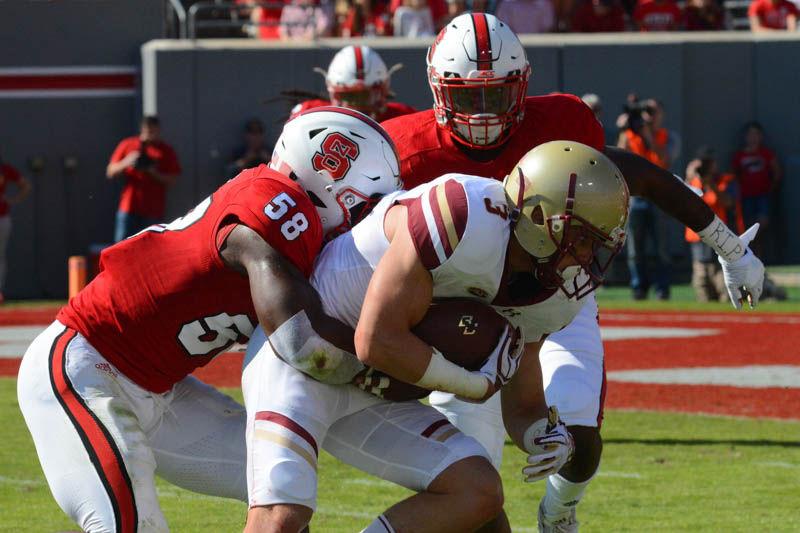 Junior linebackers Jerod Fernandez and Airius Moore tackle Boston College's sophomore wide receiver Michael Walker in Carter-Finley Stadium on Saturday. Fernandez has five unassisted tackles and seven assisted tackles. Moore has three unassisted tackles and three assisted tackles. Walker has six receptions with total of 78 yards. The game against Boston College ended with a 21-14 loss for NC State.