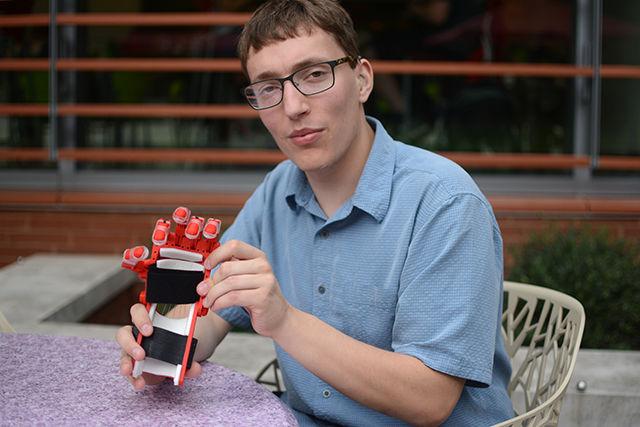 Elliot Krause, a junior studying biomedical engineering at UNC-Chapel Hill and the president of Helping Hands, shows off a prosthetic device made by the Helping Hands club at UNC-CH. Helping Hands is non-profit organization based at UNC-CH that makes prosthetic devices for children at no cost to families. The parts of the prosthetic are 3D printed and assembled with other materials such as string and elastic that allow them to move.