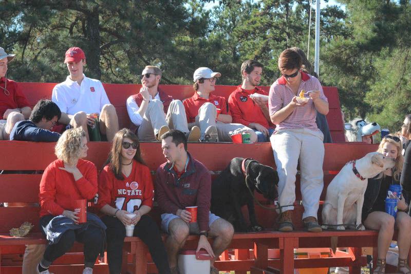 Members of the Sigma Phi Epsilon fraternity sit together on a bench at the homecoming tailgate before the homecoming game Saturday. The Wolfpack ended up losing to Boston College with a score of 21-14.